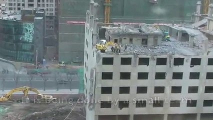 Beijing worker risks his life to demolish part of a building