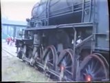 A hardworking steam turbine engine pulls heavy timber train