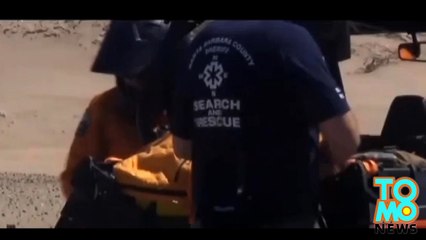 معمودية شاطئ في سانتا بربرا في منتزه الكثبان ورجل تسحبه موجة عالية