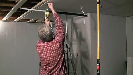 One man drywall installation on ceiling