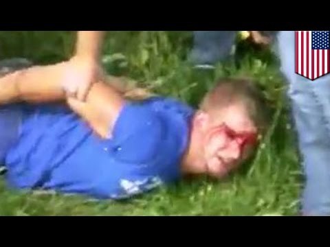 Mężczyzna poddaje się i kładzie na ziemi - policjant kopie go z rozbiegu w twarz