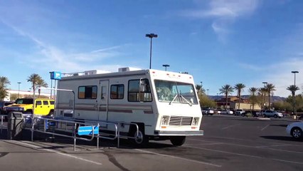 Dog pooping on the dashboard of an old RV in a Walmart parking lot