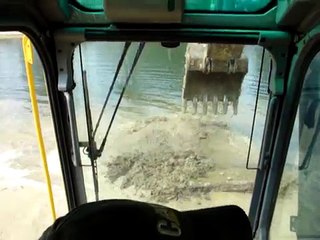 Excavator digging in a pond