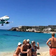 Tourist films plane's descent just mestres above packed Caribbean beach