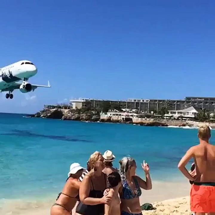 Tourist films plane's descent just mestres above packed Caribbean beach