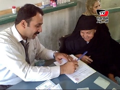 في اليوم الثاني للانتخابات.. قاضٍ يساعد إمرأة مسنة على الإدلاء بصوتها.