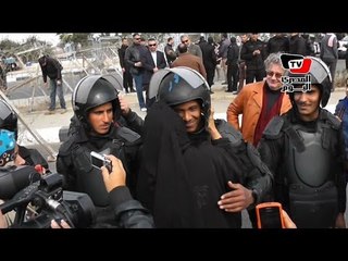 سيدة تقبل جنود تأمين محاكمة المعزول