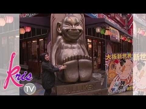 Kris takes a picture beside Billiken