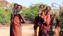 Turkana woman breastfeeds orphaned goat