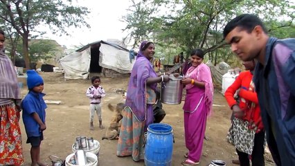 Slum-dweller in India shares food with street dogs