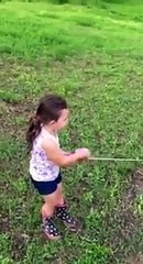 Une petite fille attrape un poisson aussi gros qu'elle