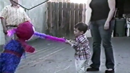 This kid doesn't want to break his pinata and hugs it... because it's a Spider-Man Pinata!