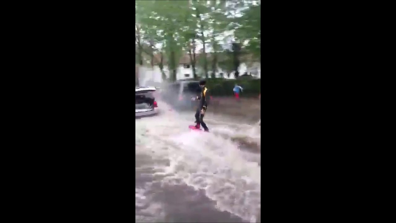 Faire du ski nautique dans une rue inondée tiré par une voiture
