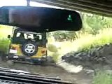 2 jeeps going through river than sharp rocks