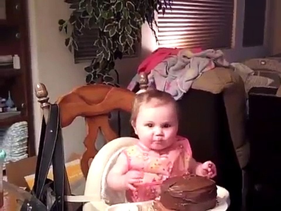 Le bébé drôle qui mange son gâteau