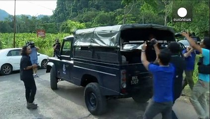 Malaysian forensic officers examine remains of migrants found along Thai border