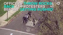 Cops in Baltimore caught throwing rocks back at protesters before the crowd fights back