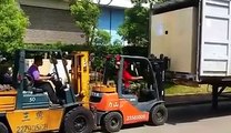 Forklift lifting a forklift to put a container into a container