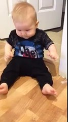 un bébé s'amuse avec un bloqueur de porte