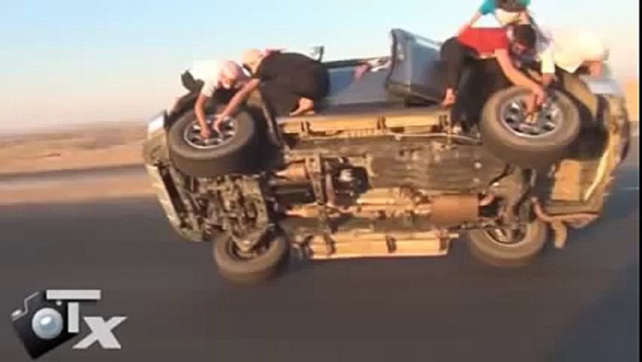 saudis changing tyres while driving