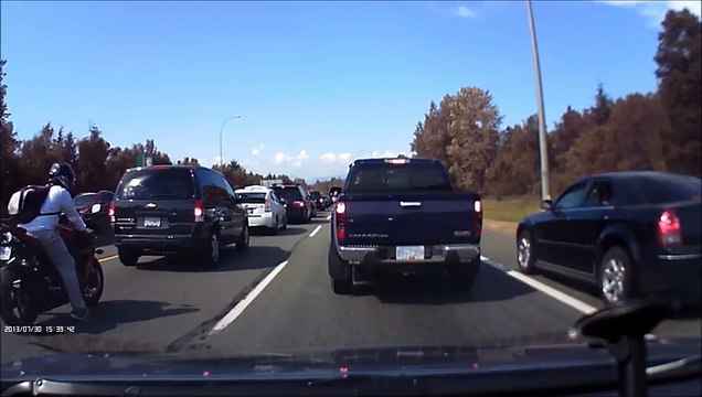 Un homme refuse de se faire doubler par une voiture roulant sur la bande d'arrêt d'urgence