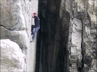 Crazy guy climbing a cliff without rope