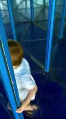 Un enfant passe devant dans un labyrinthe de miroirs