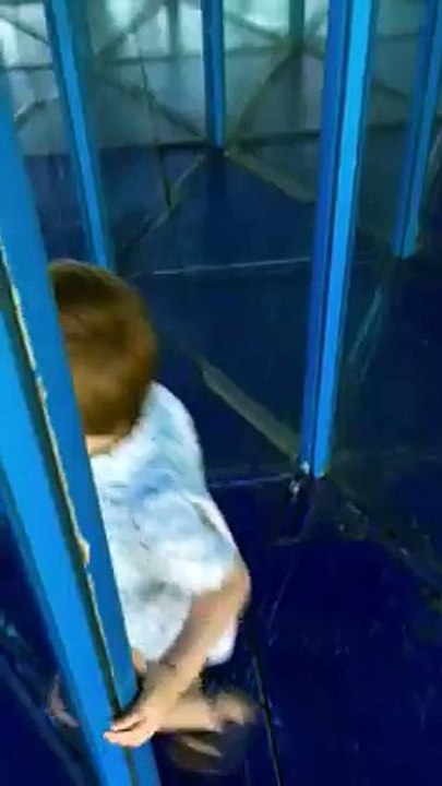 Un enfant passe devant dans un labyrinthe de miroirs