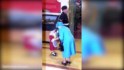 Ouch! Little girl presents a posy to the Queen... only to be smacked on the head by a saluting soldier