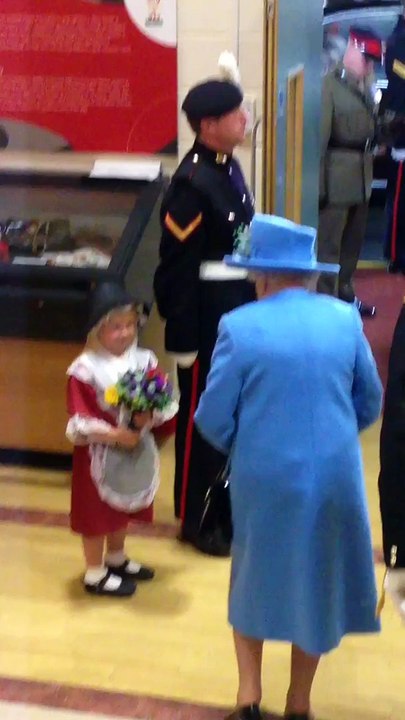 Une petite fille offre un bouquet de fleurs à la reine d'Angleterre et ce fait gifler