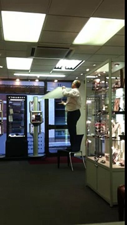 Fat optician changing a light bulb