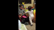 Cet enfant aide sa jeune soeur et l'encourage pour ses premiers pas  adorable!