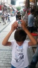 Un enfant syrien résout un Rubik's cube sans regarder et en parlant à des passants