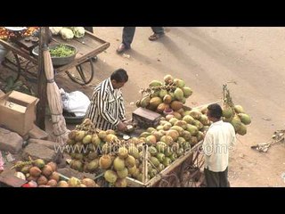 Man sells coconut water at a market in Gujarat