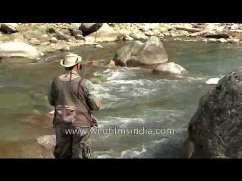 Indian Fly fisherman escorted by gillie guides