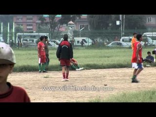 Nepali boys play soccer in a ground in Kathmandu