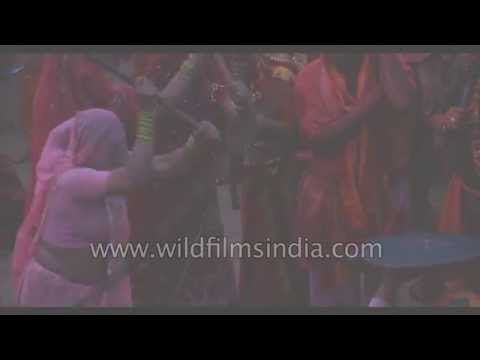 Indian villagers smear themselves with colors during Lathmar Holi festival