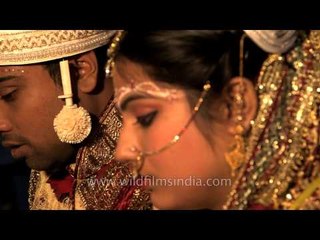 Shy Bengali bride at the wedding fire, following priest's instructions