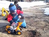 Lek med traktor och grävmaskin ute på gården
