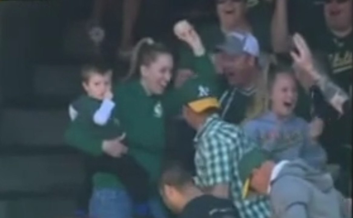 Baseball : Une spectatrice rattrape une balle d'une main avec son enfant dans les bras!