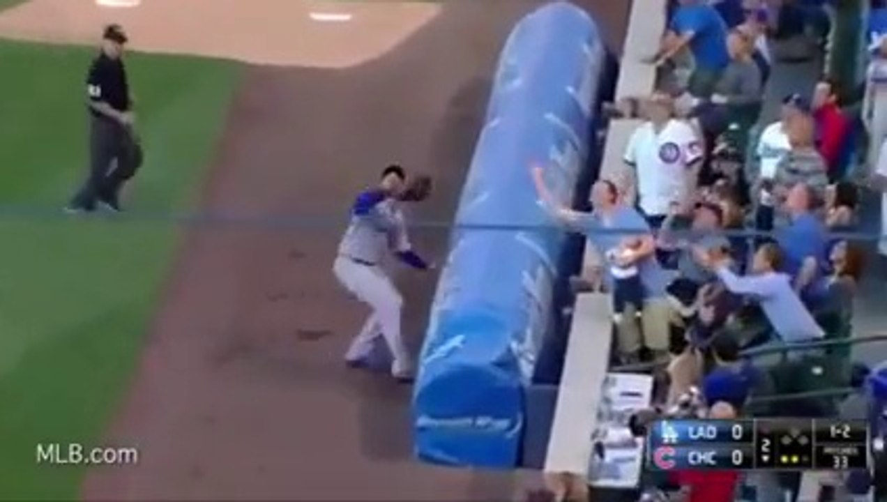 Un spectateur rattrape une balle de baseball tout en donnant le biberon à son bébé