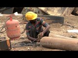 Indian worker checks gas cylinders at a ship breaking yard in Alang - India