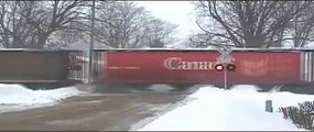 CN Extra Grain Train Flying Over Railroad Crossing in Snow