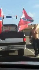 Un homme déchire des drapeaux confédérés accrochés à une voiture