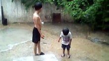 TWO KIDS, PLAYING IN RAIN, IN KARACHI