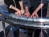 Two people playing hydraulophone (water pipe organ flute)