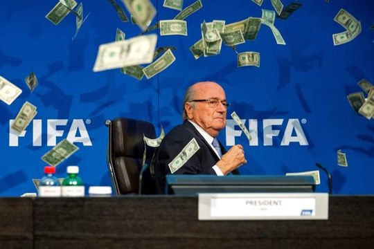 Lee Nelson balance des billets sur Sepp Blatter lors d'une conférence de presse