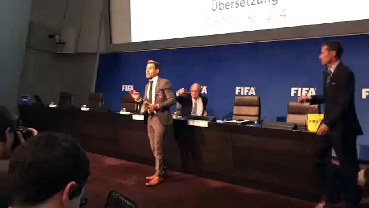 الممثل الكوميدي لي نيلسون يرمي المال على جوزيب بلاتر في أحد المؤتمرات الصحفية لـ الفيفا .