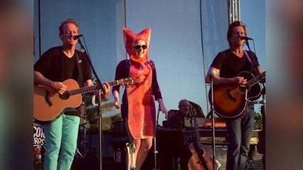 Kevin Bacon dances on stage with bacon strip during concert