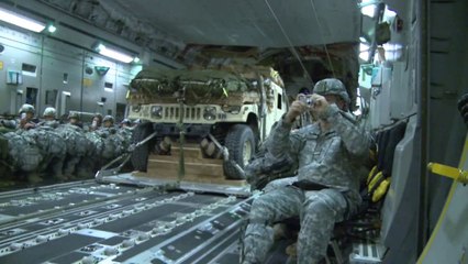 Un avion cargo C-17 de l'armée américaine largue 4 4x4 Humvee de nuit